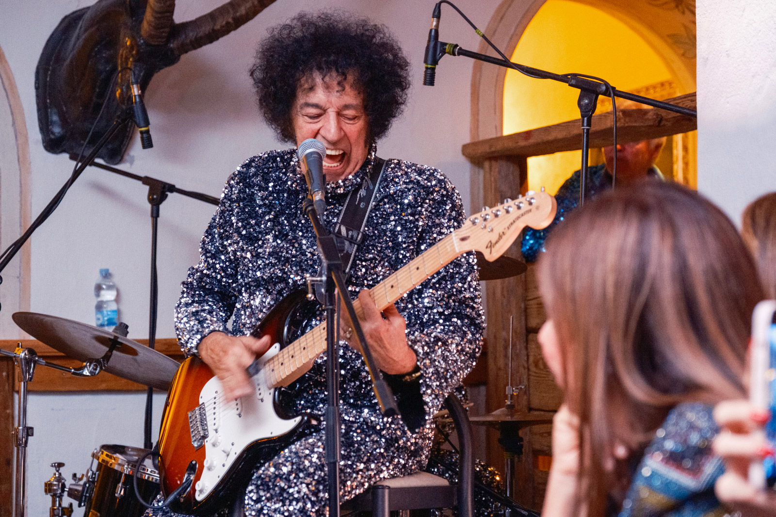 Primo piano cantante mentre suona una chitarra da rocknroll su un palco - ACCAELLE Events | Organizzazione eventi e Wedding planner