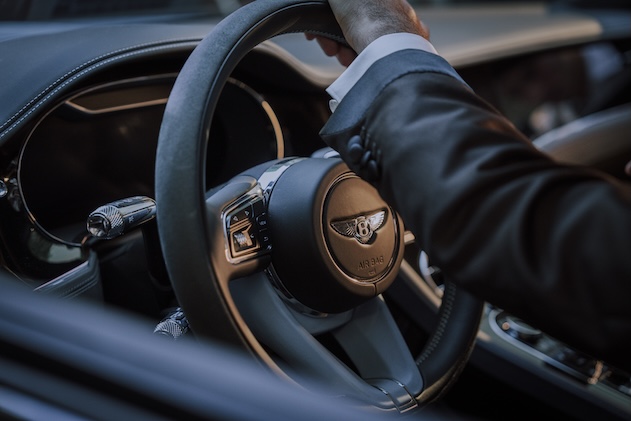 Primo piano con mano su volante Bentley continental gt - ACCAELLE Events | Organizzazione eventi e Wedding planner