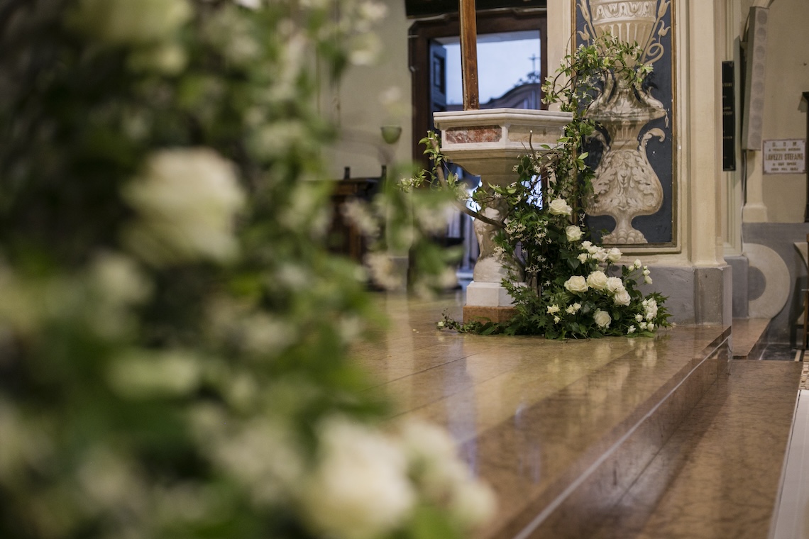 Primo piano decorazioni floreali verde bianco posti prima dell'altare ecclesiastico - ACCAELLE Events | Organizzazione eventi e Wedding planner