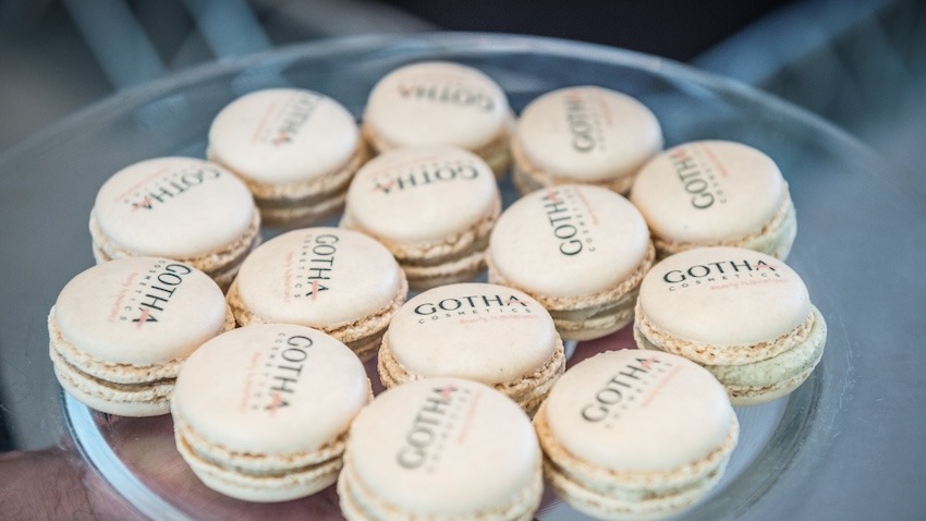 Primo piano macarons giallo tenue brandizzati con nome agenzia su vassoio in vetro  - ACCAELLE Events | Organizzazione eventi e Wedding planner