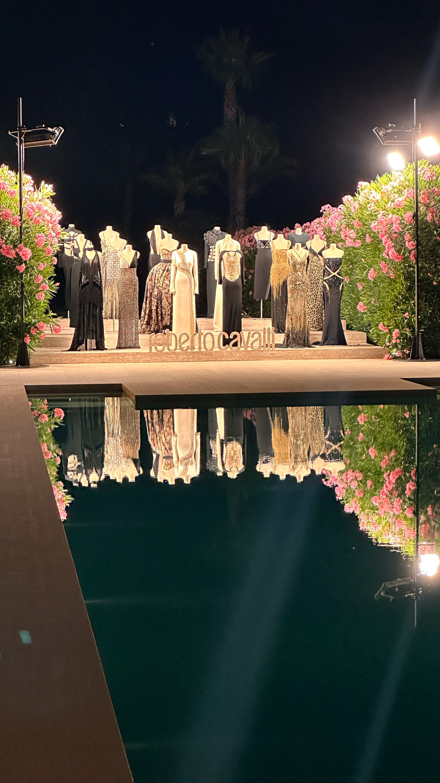 Riflesso notturno nell'acqua della piscina di un gruppo di invitati che balla a bordo vasca. - ACCAELLE Events | Organizzazione eventi e Wedding planner