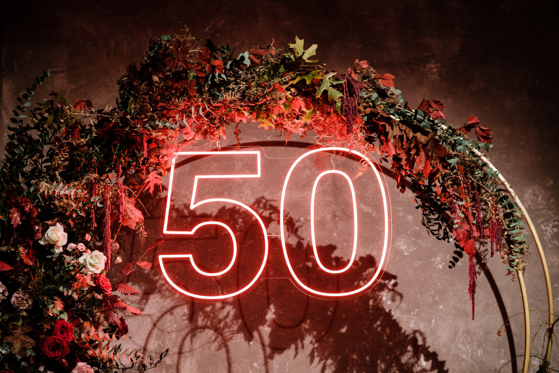 Scritta luminosa al neon con il numero 50 inserita in una ghirlanda di foglie verdi. - ACCAELLE Events | Organizzazione eventi e Wedding planner