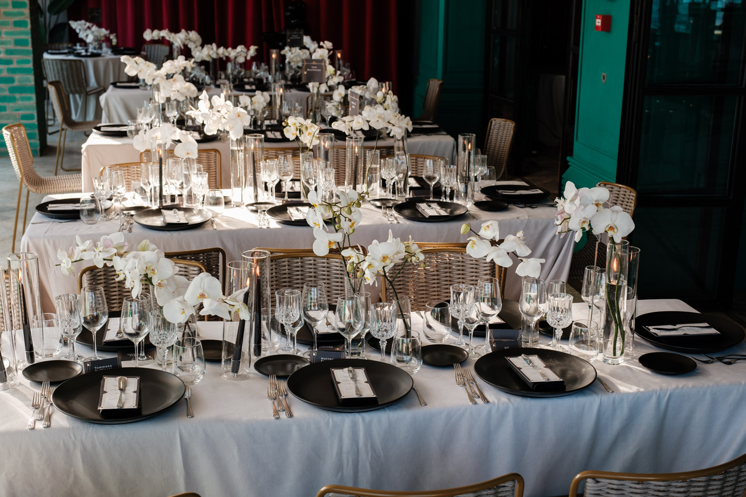 Tavola apparecchiata con eleganti piatti neri e composizioni di fiori bianchi. - ACCAELLE Events | Organizzazione eventi e Wedding planner