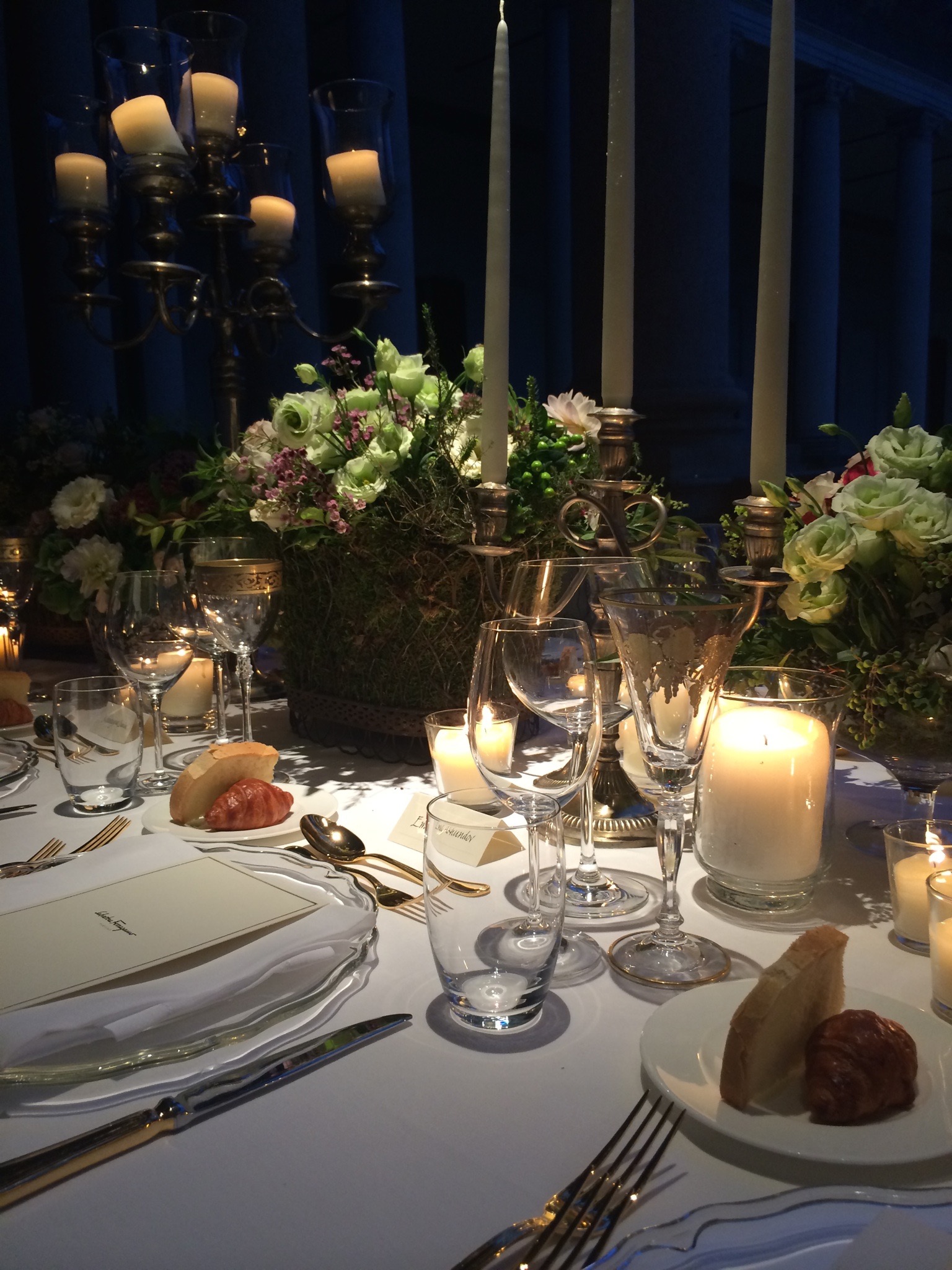 Tavola apparecchiata la sera con ricchi mazzi di fiori, candelabri e pane nel piattino. - ACCAELLE Events | Organizzazione eventi e Wedding planner