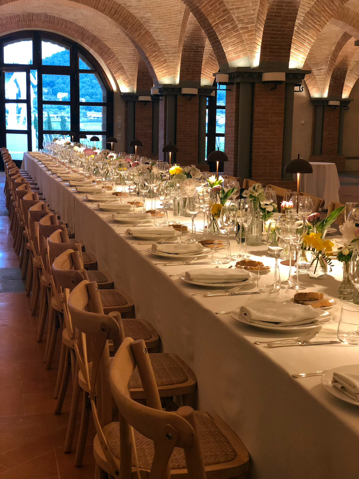 Tavolata imperiale allestita all'interno di una sala storica con soffitto a volta in mattoni. - ACCAELLE Events | Organizzazione eventi e Wedding planner