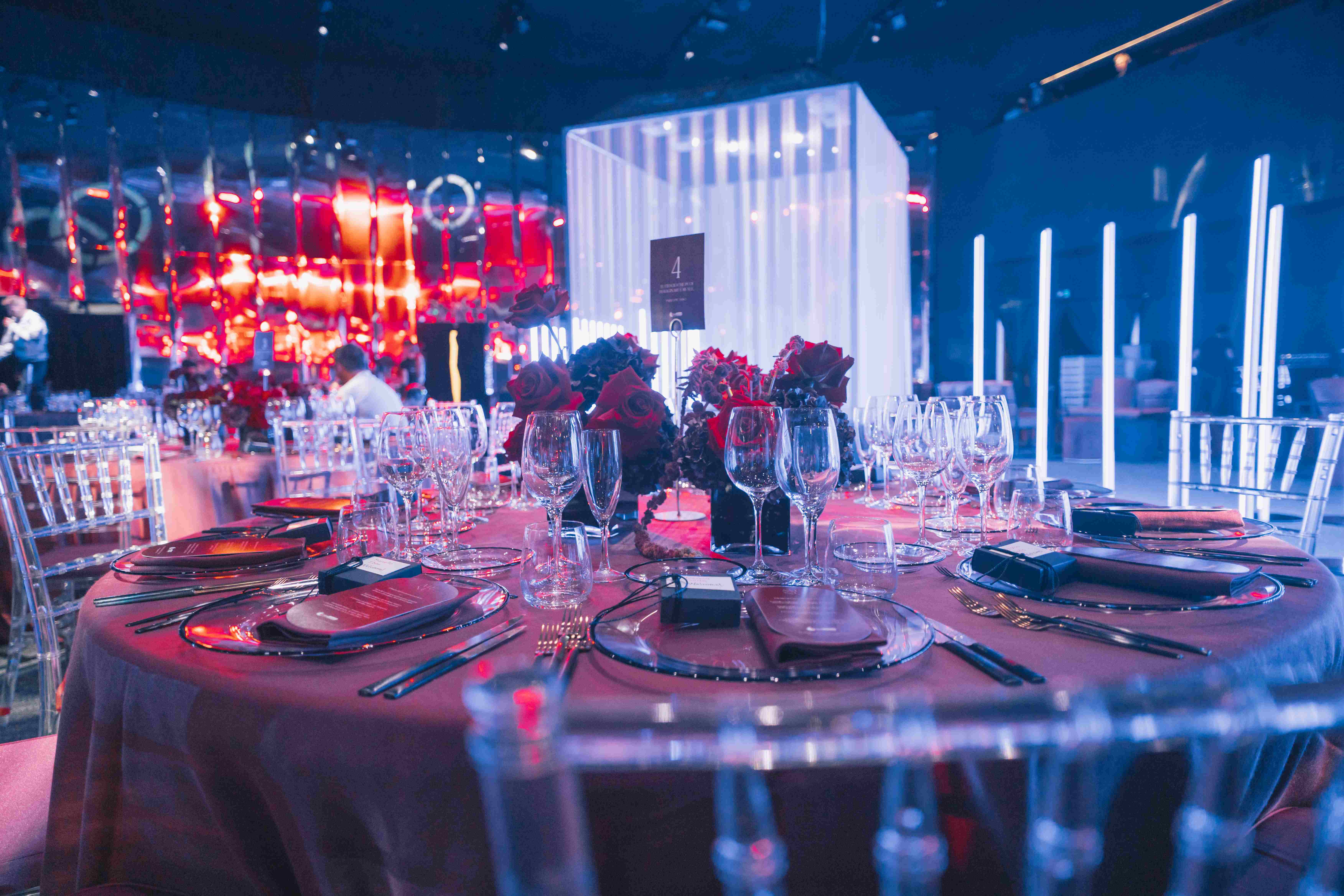 Tavolo allestito elegantemente con alle spalle una struttura cubica bianca illuminata. - ACCAELLE Events | Organizzazione eventi e Wedding planner