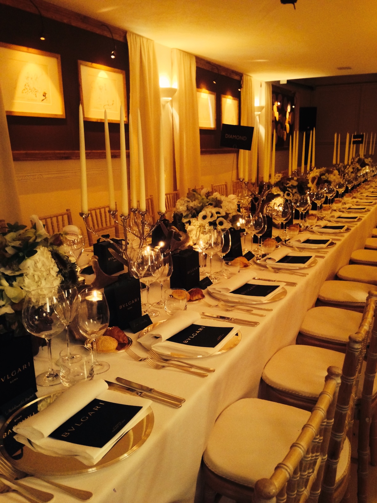 Tavolo lungo allestito elegantemente con cestini di fiori e luci calde soffuse - ACCAELLE Events | Organizzazione eventi e Wedding planner