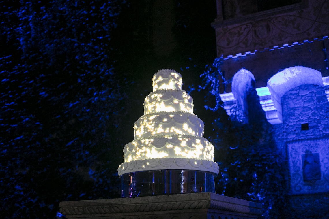 Torta nuziale a 4 piani illuminata di sera e luci blu sullo sfondo - ACCAELLE Events | Organizzazione eventi e Wedding planner