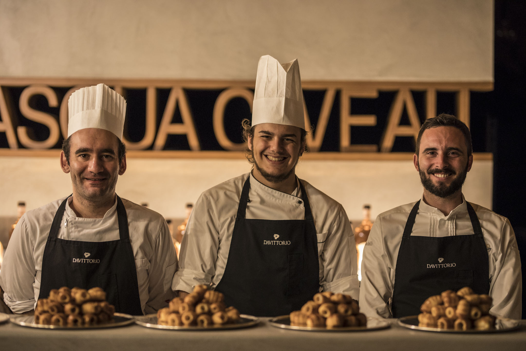 Trio di commensali dietro ad un bancone con finger food in rilievo  - ACCAELLE Events | Organizzazione eventi e Wedding planner