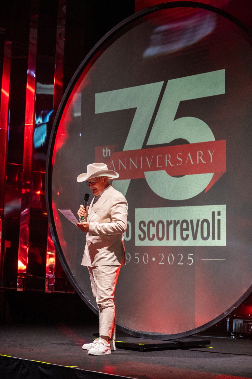 Uomo con cappello da cowboy parla sul palco davanti al logo del 75° anniversario. - ACCAELLE Events | Organizzazione eventi e Wedding planner