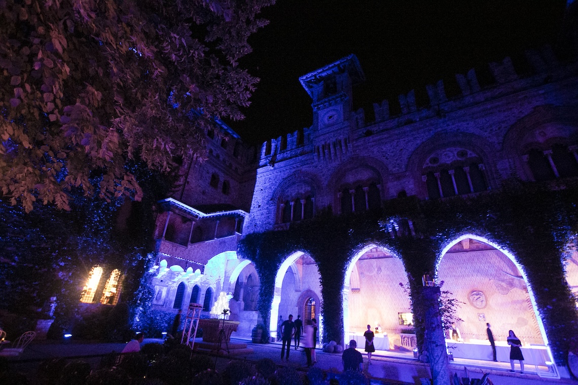 Vista dal basso edificio antico con portico illuminato da luci blu in serata - ACCAELLE Events | Organizzazione eventi e Wedding planner