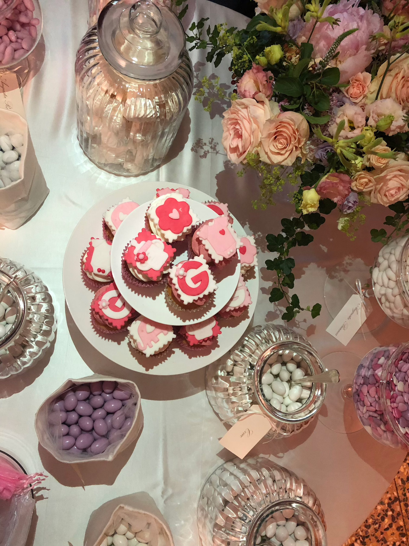 Vista dall'alto tavolo con dolci bianchi e rosa e cestino di fiori - ACCAELLE Events | Organizzazione eventi e Wedding planner